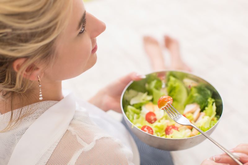 dieta ujemnych kalorii - jedzenie sałaty z pomidorem
