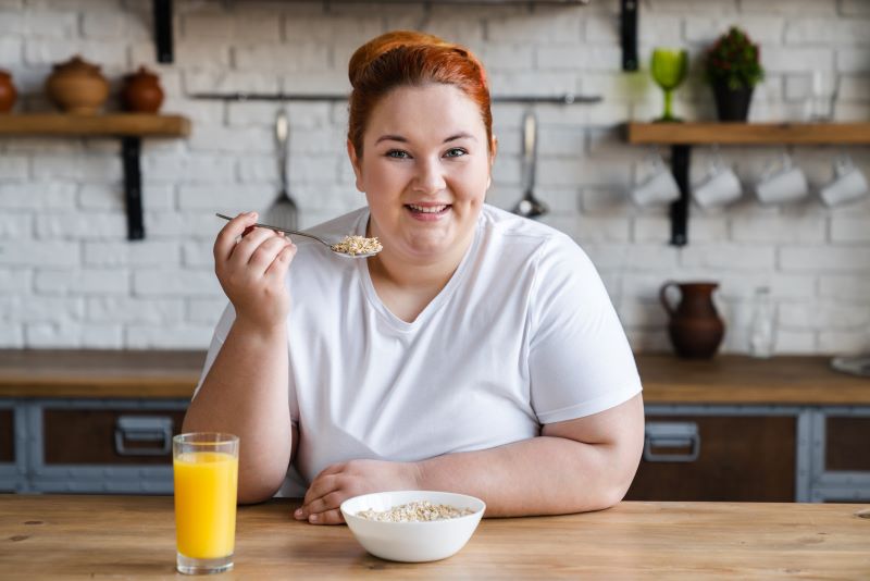 Kobieta zaczynająca dietę kobieta z nadwagą je w kuchni