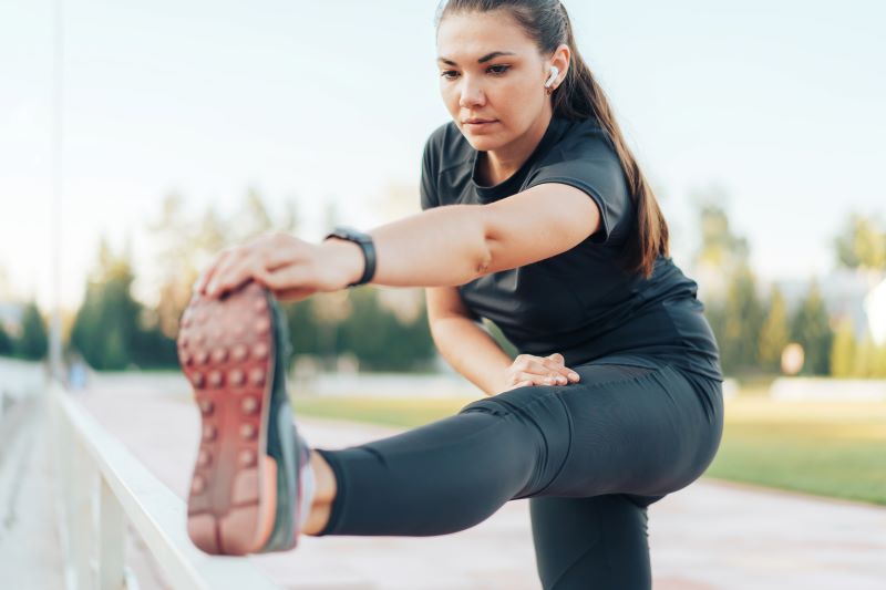 kobieta robiąca stretching dla początkujących w parku