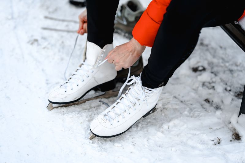 Wiązanie butów łyżew przed wejściem na lodowisko