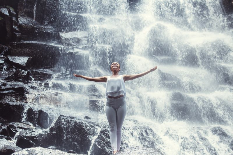 kobieta prowadząca zdrowy tryb życia szczęśliwa na tle wodospadu