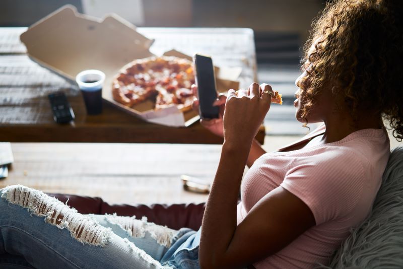Jedzenie pizzy na kanapie kobieta jedząca pizzę na wieczór