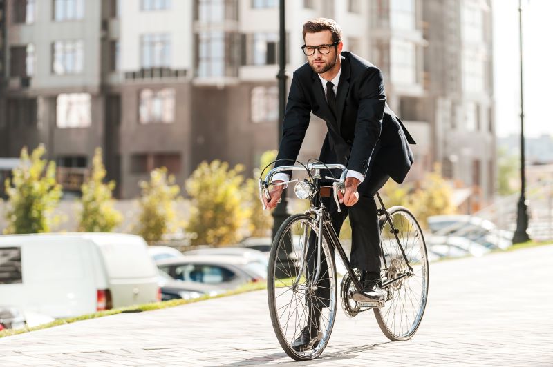 Jechanie rowerem do pracy w garniturze biznesmen jadący do pracy na rowerze