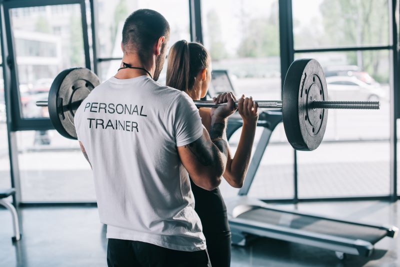 Trening ze sztangą na siłowni z trenerem stacjonarny trening osobisty ze sztangą