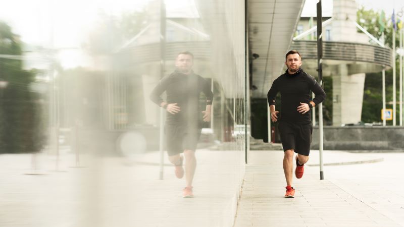 Mężczyzna uprawiający slow jogging na mieście