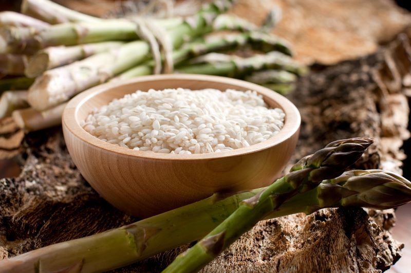 ugotowany ryż w misce i szparagi surowe