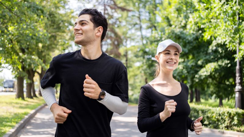 Uśmiechnięta para joggerów Uśmiechnięta para na slow joggingu