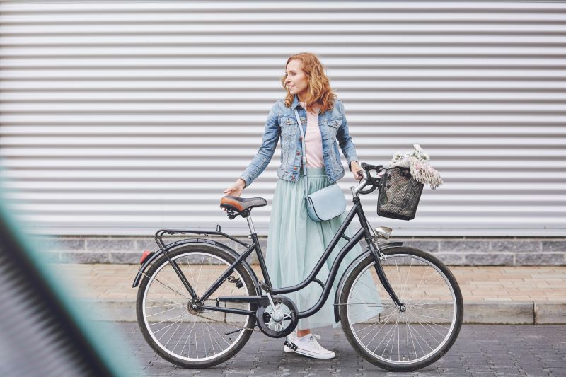 kobieta z rowerem miejskim z koszykiem