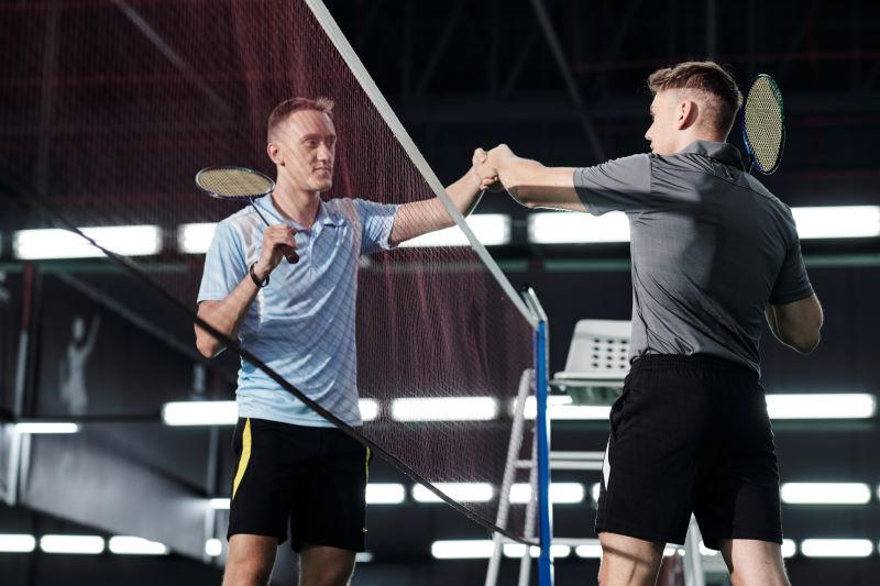 Badmintoniści podający sobie ręce przeciwnicy w badmintonie podający sobie dłonie