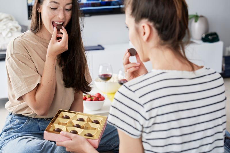 zajadanie się czekoladkami na babskim wieczorze - dwie kobiety