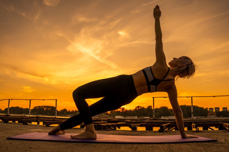Pilates ćwiczenia dla początkujących - na zewnątrz Kobieta robiąca pilates dla początkujących na dworze